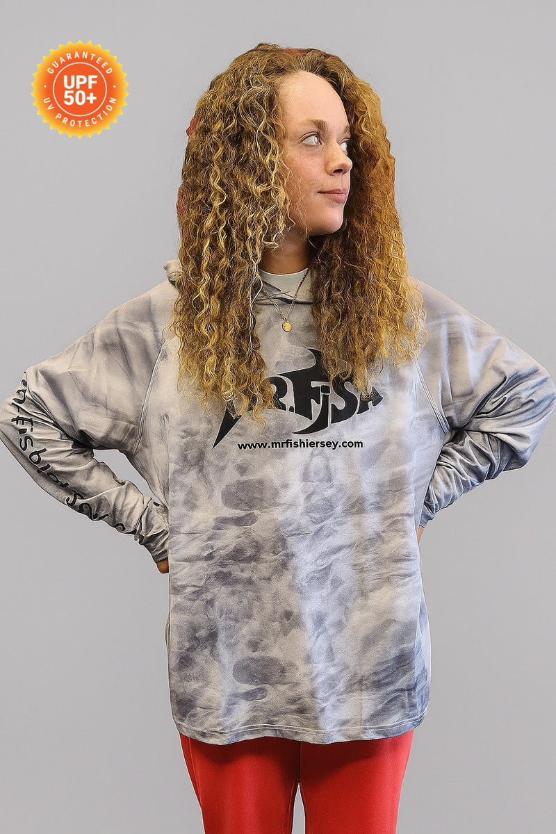 Person wearing a tie-dye long-sleeve shirt with a visible brand logo on a gray background
